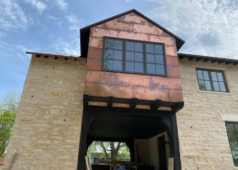 Copper metal panel facade on a stone building for Skylight Installation in Osceola