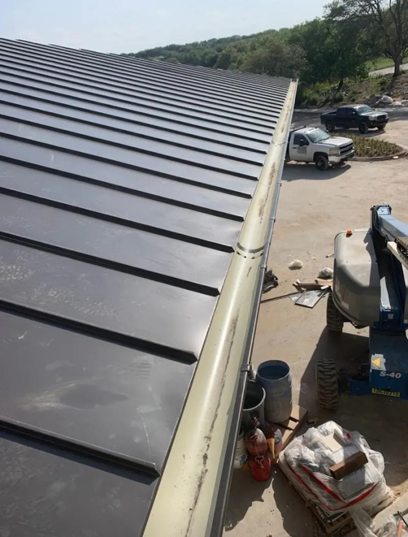 Standing seam panel and gutter detail on a metal roofing jobsite in Osceola
